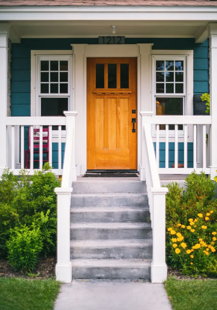 Craftsman wood front door with teal siding