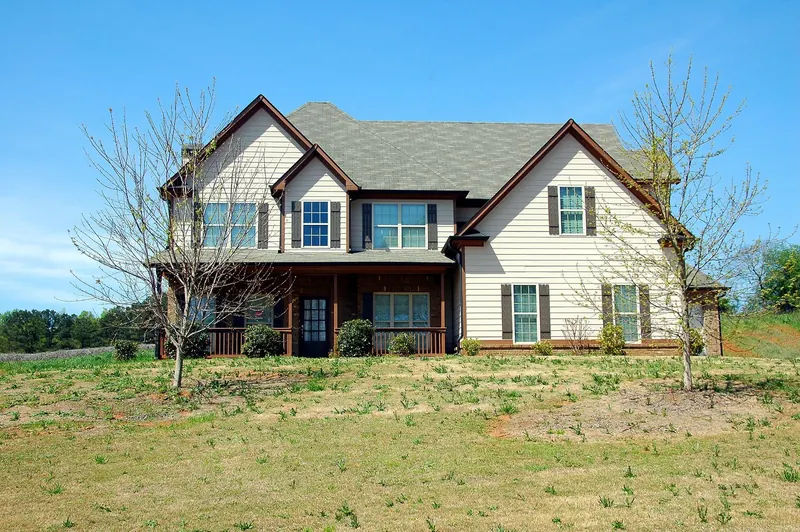 Cream two-story home with a front porch and grid double-hung windows